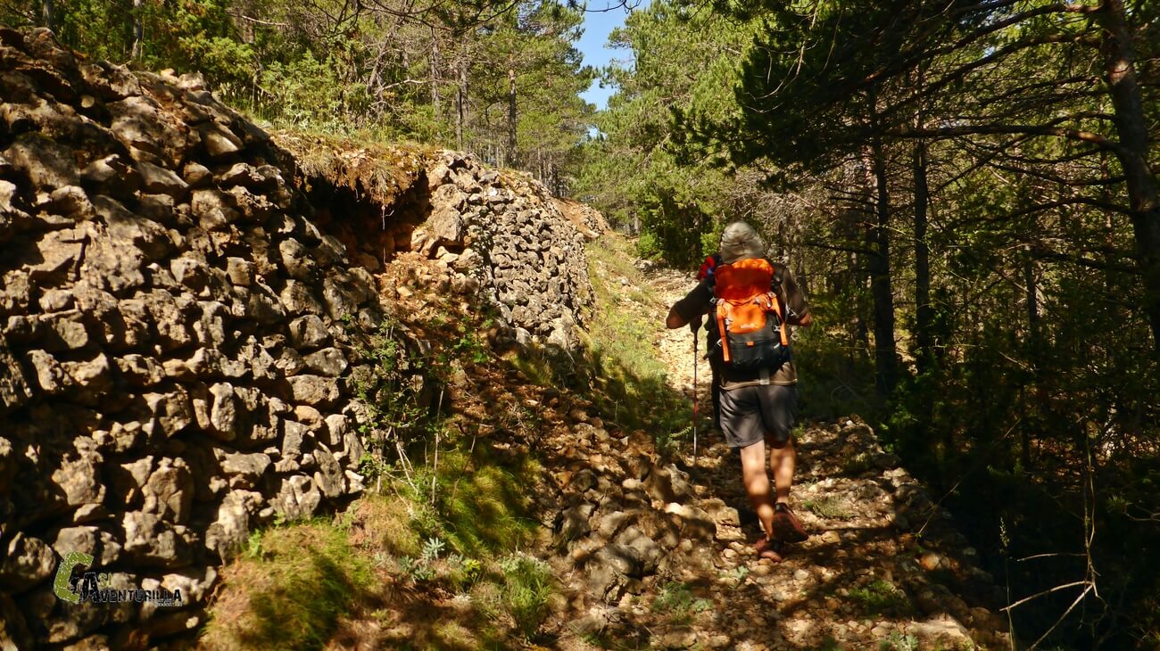 Por sendero junto a un muro de piedras